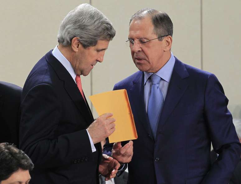 O americano John Kerry (esq.) recebe envelope do chanceler russo, Sergei Lavrov, durante encontro da Otan, em Bruxelas