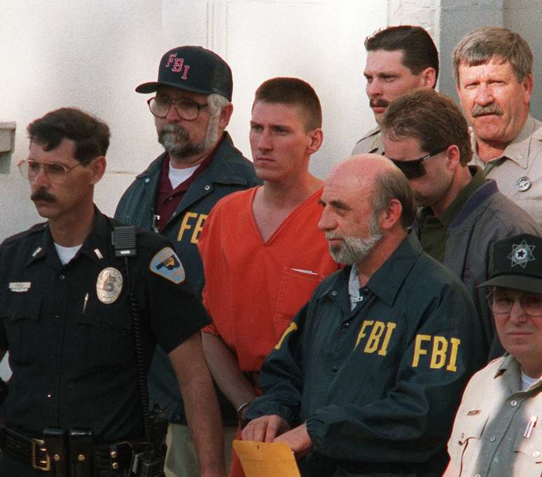 Imagem de 21 de abril de 1995 mostra Timothy McVeigh (centro) sendo escoltado pela pol&iacute;cia em Perry, Oklahoma