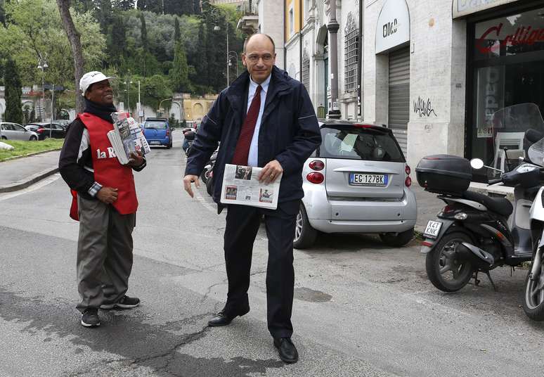 O primeiro-ministro designado da Itália, Enrico Letta, compra jornal ao deixar sua casa no centro de Roma nesta quinta-feira