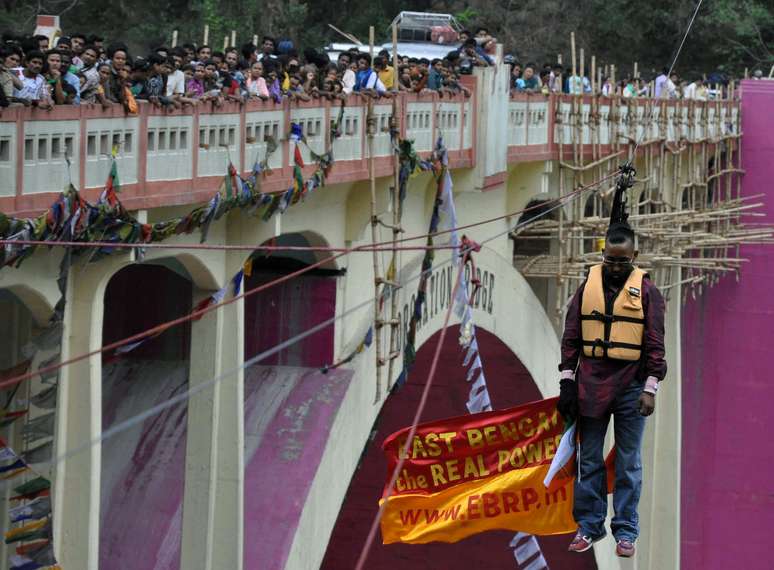 <p>Imagem mostra Sailendra Nath Roy j&aacute; morto ap&oacute;s ficar preso durante a tentativa. Roy tentava cruzar uma ponte sobre um rio nas proximidades da localidade de Siliguri no domingo suspenso por um cabo de cerca de 180 metros de comprimento, informou a&nbsp;<em style="margin: 0px; padding: 0px; border: 0px; vertical-align: baseline; background-color: transparent;">BBC</em>. Testemunhas disseram que ele travou ap&oacute;s cruzar a metade do caminho</p>