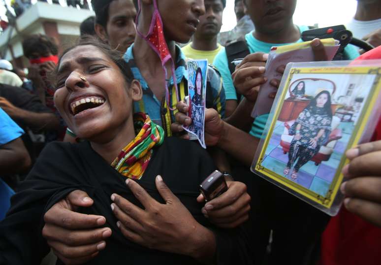 Farida chora durante sua busca pelo corpo da cunhada Fahima no dia 1º de maio, em Daca