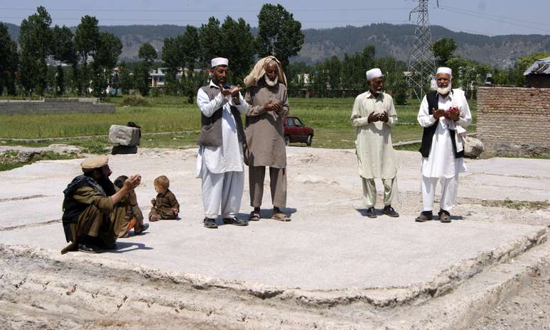 Grupo de paquistaneses reza no lugar onde antigamente se encontrava a casa de Bin Laden, em Abbottabad, em 2 de maio