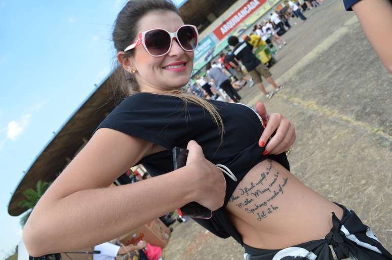 <p>A fã gaúcha Aline mostra tatuagem em homenagem aos Beatles em frente ao estádio Serra Dourada</p>