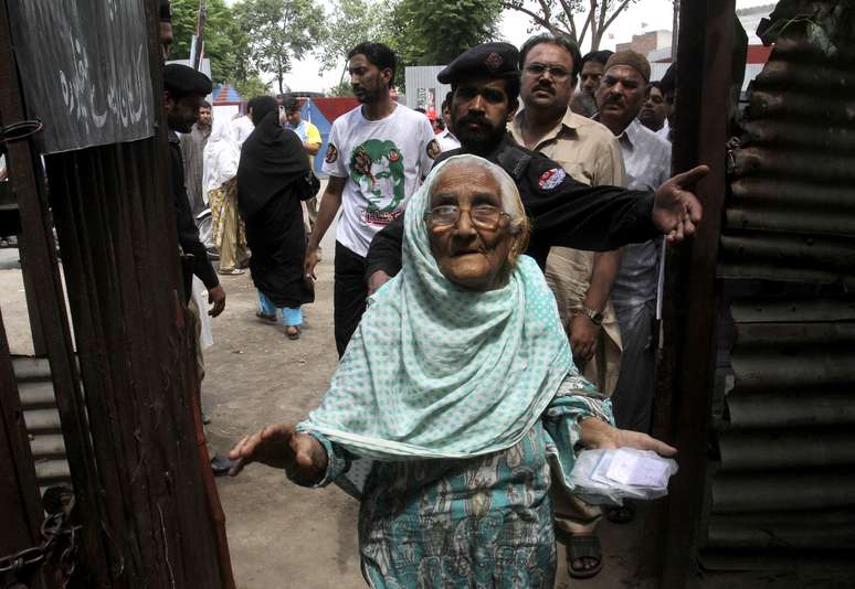 Senhora deixa zona de votação em Lahore após participar do pleito paquistanês