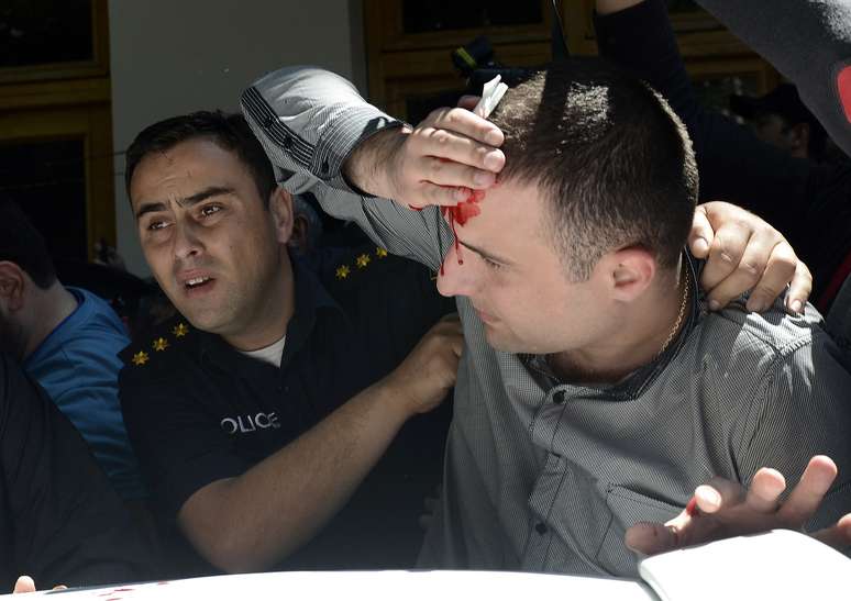 Policial auxilia homem ferido na manifestação