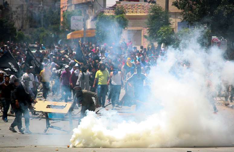 Membros do grupo radical Ansar al-Shariah confrontam a polícia no bairro de Ettadhamen, em Kairouan