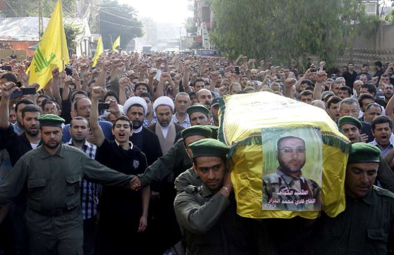 Acompanhados de uma multidão, membros do Hezbollah carregam o caixão de Fadi Jazar durante seu funeral em Beirute