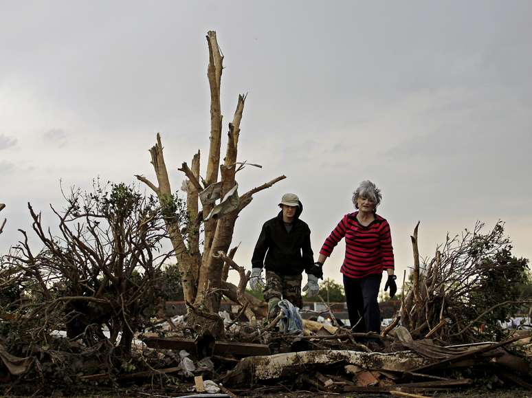 Lea Bessinger e o filho John procurando por itens para salvar em meios aos destroços de casa, em Moore