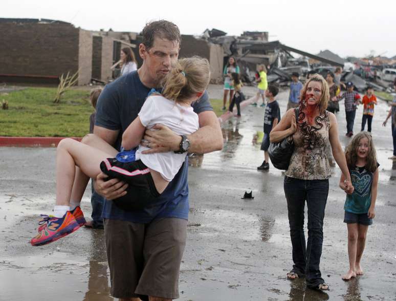 Professores carregam crianças para longe do colégio primário Briarwood, depois que um tornado destruiu a escola, no sul de Oklahoma