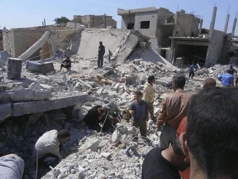Civis procuram por sobreviventes em meio a destroços após suposto bombardeio do Exército em Al Quseir, na terça-feira
