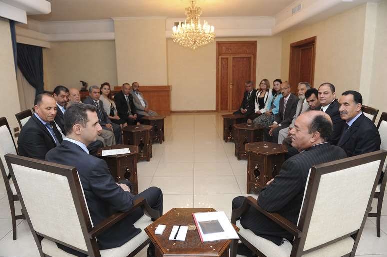 Assad (esq.) conversa com representante tunisiano durante encontro em Damasco