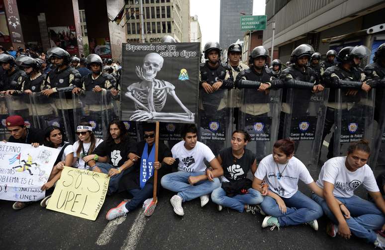 Estudantes e professores protestam em frente à polícia em Caracas