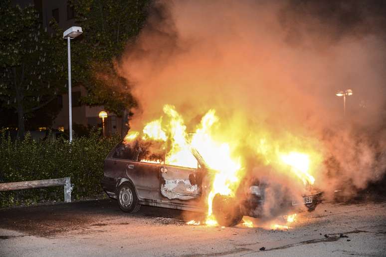 Foto do dia 21 de maio mostra carro em chamas após distúrbios em Kista, no subúrbio de Estocolmo