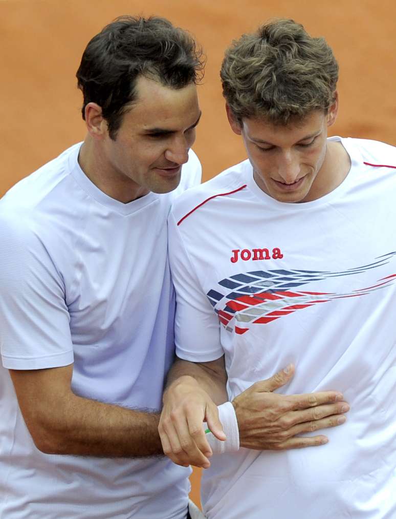 Federer cumprimenta Pablo-Carreno Busta durante vitória fácil na estreia em Roland Garros