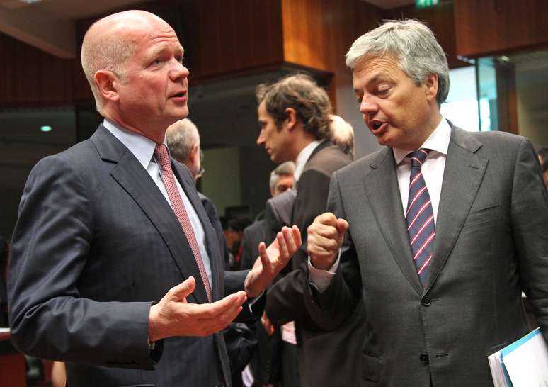 O ministro britânico William Hague (esq.) conversa com o colega belga Didier Reynders durante reunião da UE em Bruxelas