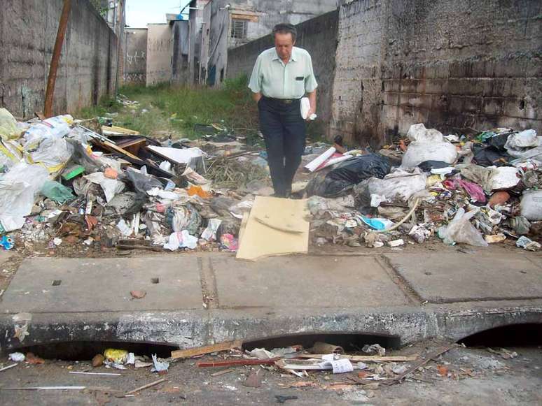 <p>Pedestre caminha em meio a lixo descartado em viela na zona norte da capital paulista</p>