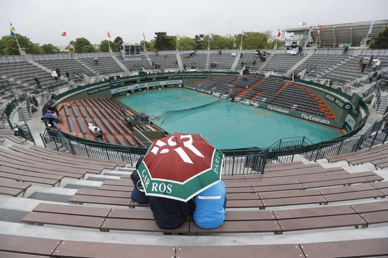 <p>Torcedor se protege da chuva na Quadra 1 de Roland Garros</p>