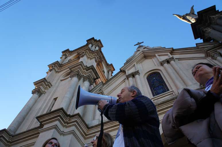 Manifestante usa megafone durante protesto em frente à Igreja das Dores, em Santa Maria