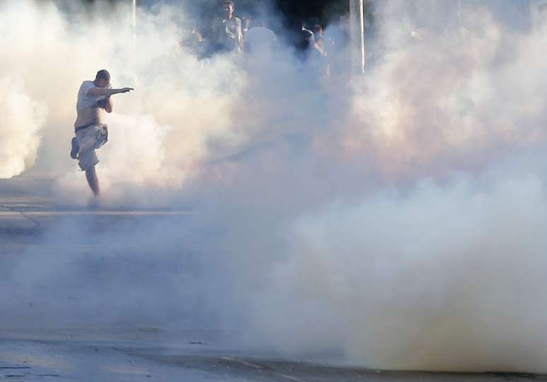 <p>Manifestante joga uma lata de gás lacrimogênio de volta para a polícia durante manifestação na Turquia</p>