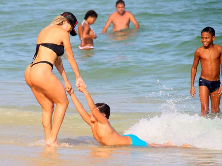 Andrea Andrade e o filho Rinaldo, 7 anos, aproveitaram o calor do Rio de Janeiro, neste domingo (1), para brincar na praia da Barra da Tijuca. A modelo e musa do Carnaval chamou atenção com seu micro biquíni de oncinha