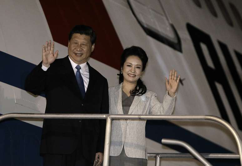 Xi acena ao lado da mulher