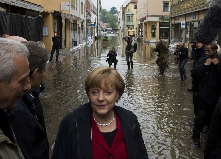 Merkel caminha por uma rua inundada da cidade de Pirna