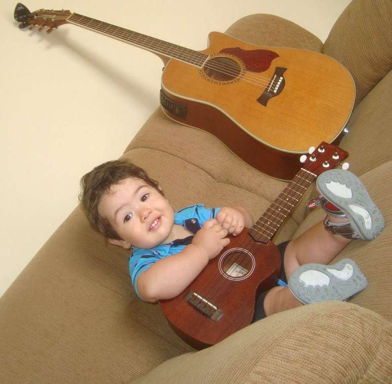 O pequeno Diogo posa com o ukulele, instrumento do pai que o tornou um sucesso na internet