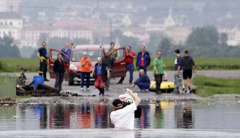 Pessoas observam homem cruzar &aacute;rea alagada em Nove Kopisty, na Rep&uacute;blica Checa