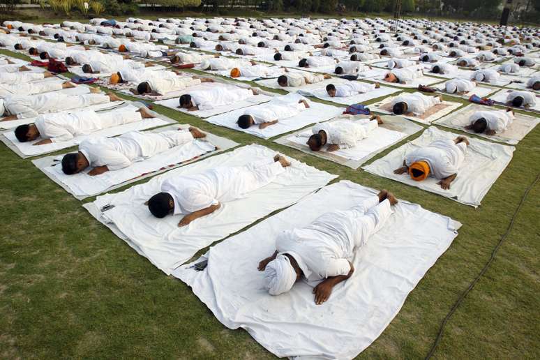 Centenas de pessoas participam de uma sessão de ioga ao ar livre organizada pela Bhartiya Yog Sansthan, associação indiana especializada na prática, em Amritsar, no noroeste da Índia. O evento teve como tema a pressão arterial, com exercícios voltados para que os participantes aprendam a reduzir a pressão