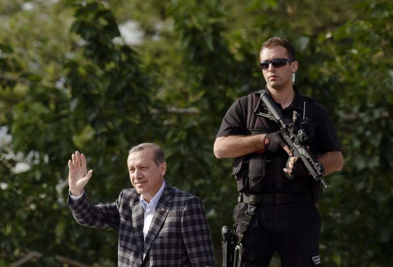 <p>O premi&ecirc; turco, Recep Tayyip Erdogan, acena a apoiadores ap&oacute;s a chegada a Ancara</p>