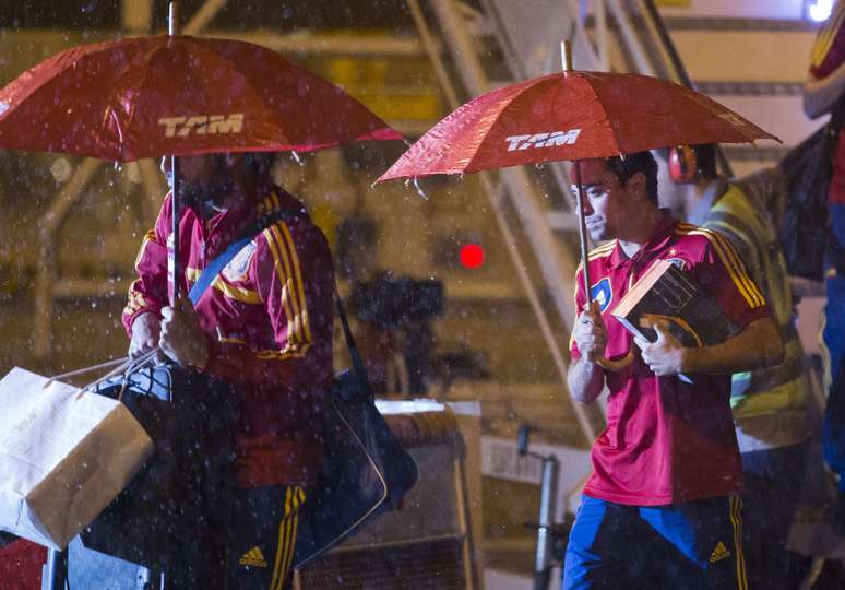 <p>Debaixo de muita chuva, meias Fabregas e Xavi, do Barcelona, desembarcam no Aeroporto Internacional dos Guararapes nesta terça-feira</p>