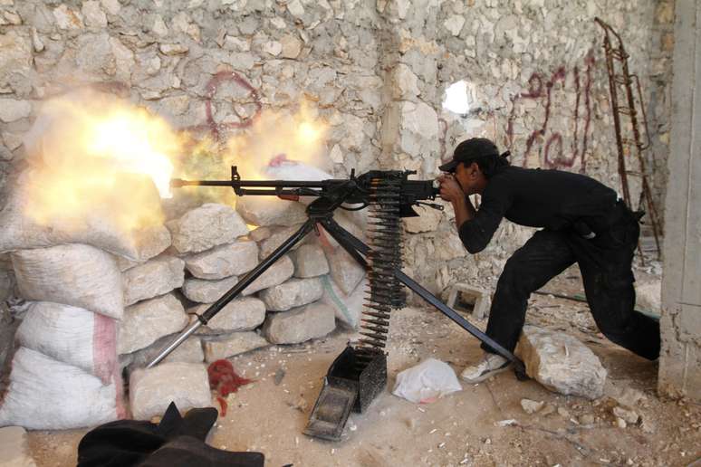 Rebelde do Exército Livre Sírio dispara durante confronto pelo controle de hospital em Aleppo