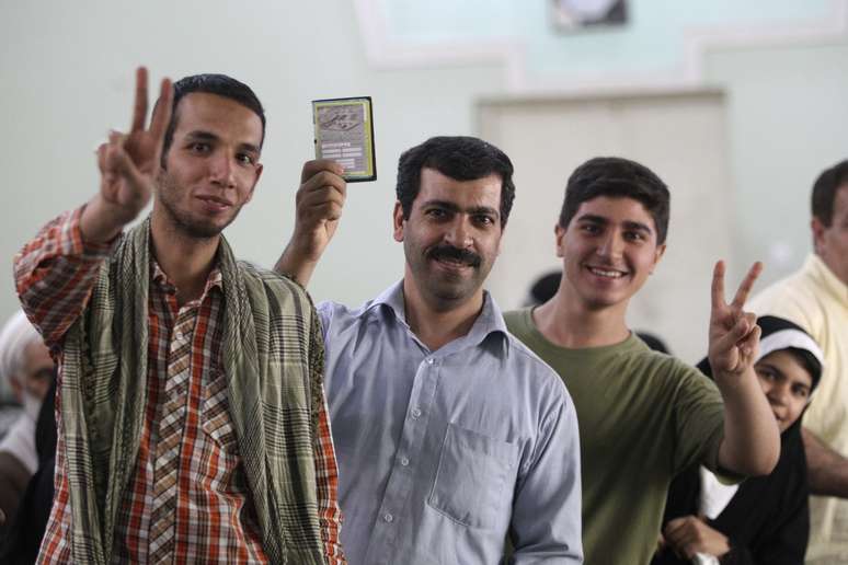 Iranianos possam para fotos enquanto aguardam para votar