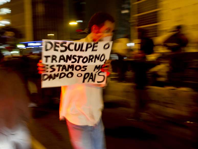 <p>Manifestante carrega cartaz durante protesto</p>