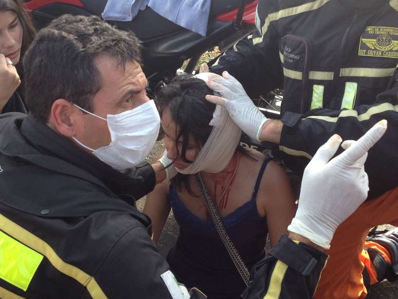 Mulher recebe atendimento após o ferimento na cabeça. Manifestação contra o dinheiro gasto com a Copa do Mundo foi realizada em Brasília