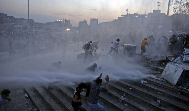 <p>Manifestantes correm após a polícia usar jatos de água no parque Gezi,  em Istambul</p>