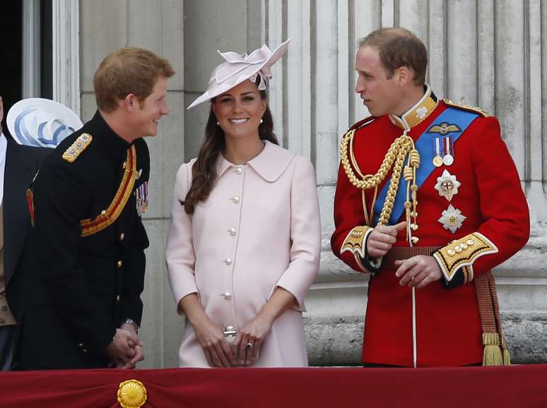 Kate, que espera um filho para julho, exibe a barriga durante conversa com o marido, o príncipe William (dir.), e o cunhado Harry 