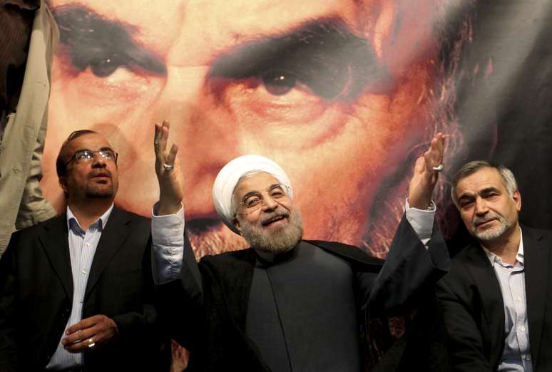 Rohani em frente a cartaz com a imagem do aiatolá Khami em comício em Teerã no dia 1º de junho
