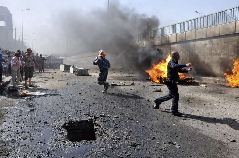 Policiais trabalham para controlar chamas logo após explosão de carro-bomba em Nasiriyah