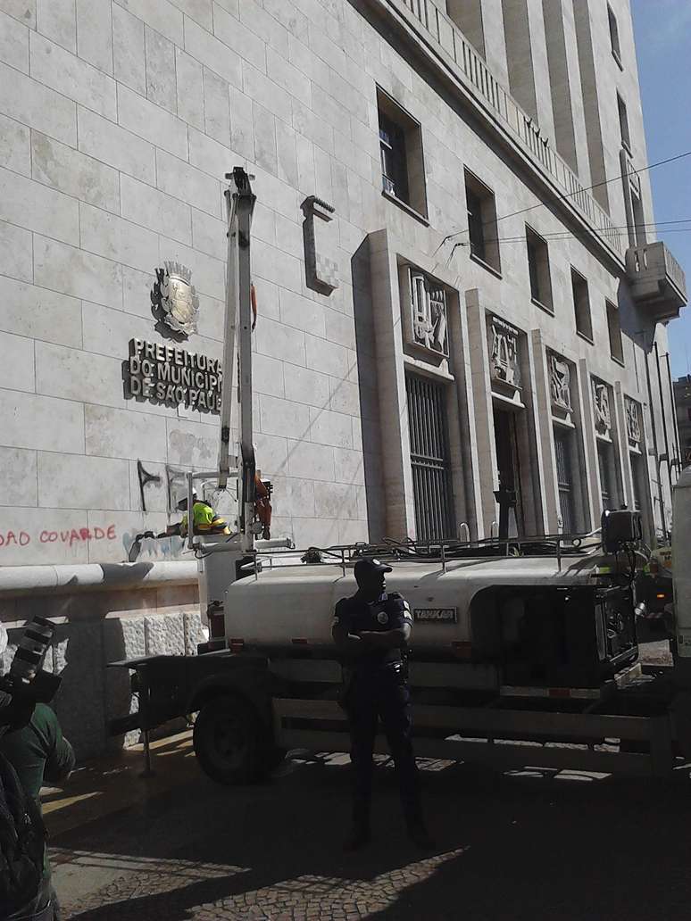 <p>Funcionários da prefeitura de São Paulo trabalham na limpeza e no conserto do prédio, após os atos de vandalismo em meio aos protestos nesta terça-feira</p>