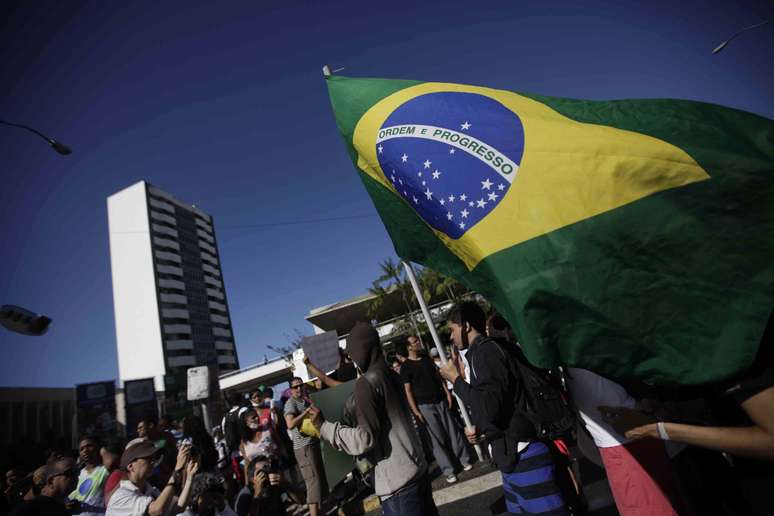 <p>Manifestante segura uma bandeira nacional no protesto na capital baiana</p>