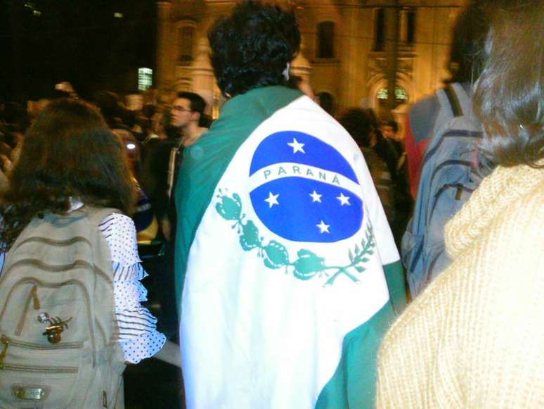 <p>Manifestante participa de protesto envolto na bandeira brasileira</p>