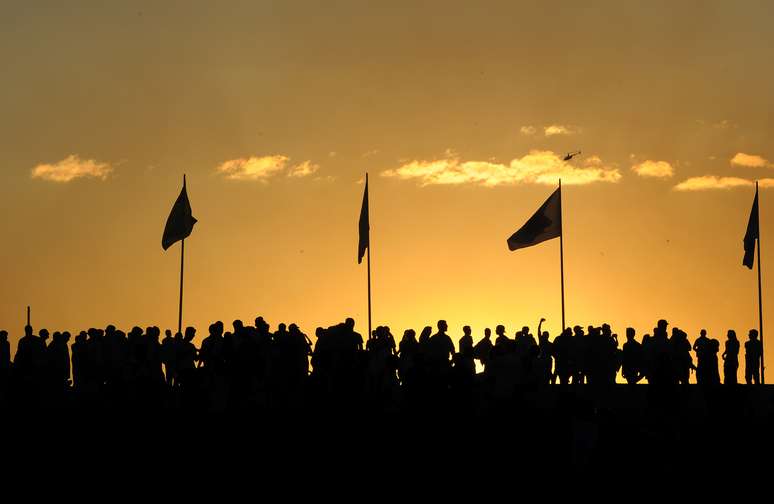 <p>Manifestantes se reúnem ao por do sol antes do início dos protestos na Esplanada dos Ministérios, em Brasília</p>