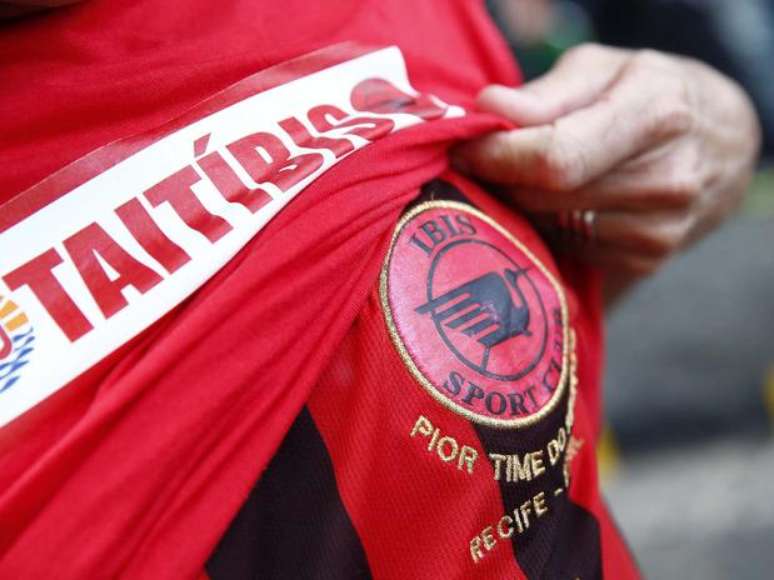 Torcedora mostra camisa de fictícia equipe híbrida do Íbis, pior time do mundo, e do Taiti, o pior do torneio