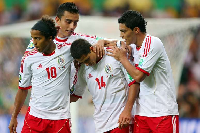 <p>Atacante mexicano é cumprimentado por colegas após marcar um de seus gols sobre o Japão</p>