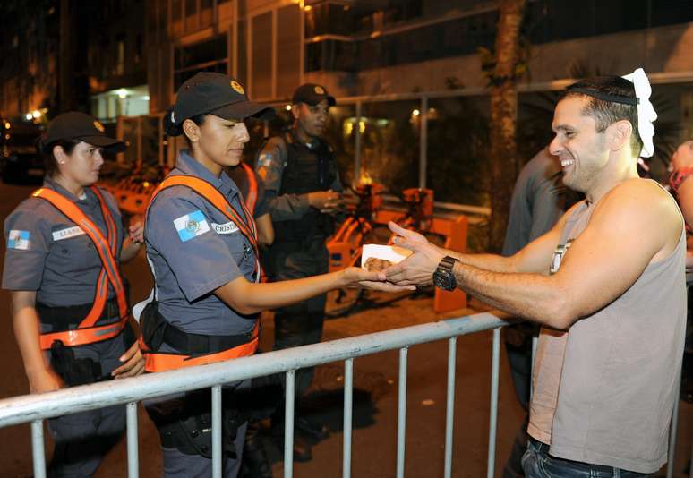 <p>Manifestantes oferecem pedaços de bolo a policiais em um protesto perto da casa de Sérgio Cabral</p>