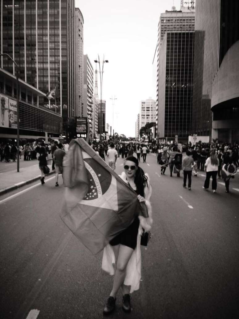 A cantora posou com uma bandeira do Brasil