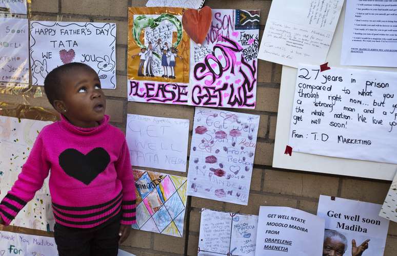 Otsile Maenetja, 3 anos, observa mensagens de apoio na entrada do hospital em que Mandela está internado