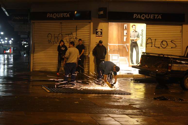 <p>Técnicos consertam porta depredada durante confrontos no Centro de Porto Alegre</p>