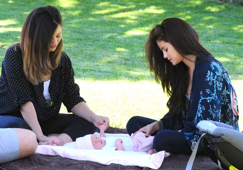 Selena Gomez ganhou uma irm&atilde;zinha no no dia 13 de junho e aproveitou os intervalos de um ensaio fotogr&aacute;fico para brincar com a nova integrante da fam&iacute;lia em Los Angeles